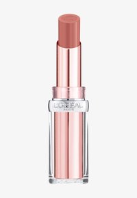 Läppstiftstube med en genomskinlig bas. Det yttre höljet är metalliskt rosguld, och själva läppstiftet är en mjuk nude-rosa. Har varumärkets logotyp på toppen.