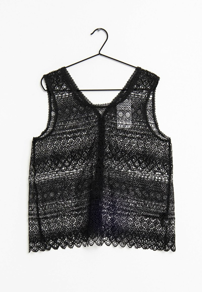 Zwart kanten tanktop met ingewikkelde patronen, voorzien van een ronde hals en een gescalpe zoom, hangend aan een zwarte haak tegen een witte achtergrond.