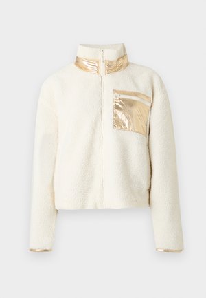 Faux shearling jacket in cream with a high collar and metallic gold accents. Features a zippered pocket on the chest and cuffs.