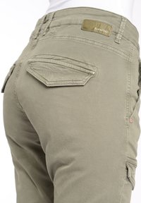 Zelené bavlněné cargo kalhoty s přiléhavým střihem, které mají dvě zadní kapsy a koženou nášivku na pásku.