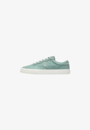 Sneaker basso in tela verde tenue con lacci bianchi, suola spessa bianca e un piccolo logo a forma di albero sul lato.