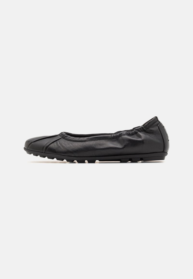 Ballerine plate en cuir noir à enfiler avec arrière élastique et semelle en caoutchouc, présentée de profil sur fond blanc.