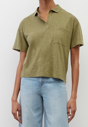 Polo en vert olive, coupé court, avec un col classique, des manches courtes et une poche poitrine ; fabriqué en tissu léger et texturé.