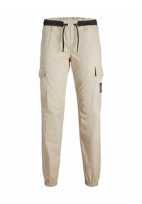 Pantalon cargo beige avec taille et poignets élastiques, cordon noir et poches à rabat sur chaque cuisse, présenté sur fond blanc.