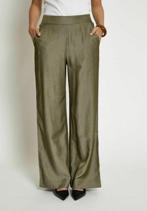 Olive green, wide-leg trousers made from a smooth, lightweight fabric, featuring side pockets and a flat waistband, paired with black pointed shoes.