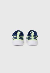 Baskets de sport bleues et vertes avec une tige en mesh, semelle blanche, sangle ajustable et talon rembourré pour le confort et le soutien.