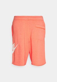 Pantalones cortos de forro polar Nike color naranja coral con cintura elástica, bolsillo trasero y logo blanco de Nike en la pierna izquierda.