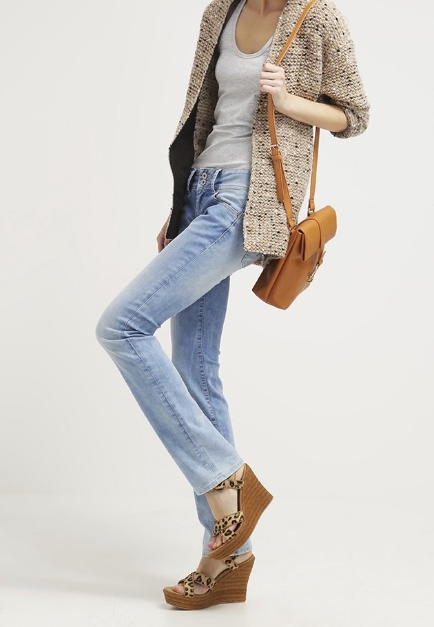 Jeans azzurri, cardigan beige in maglia, canotta grigia, borsa a tracolla marrone, sandali con zeppa beige con stampa leopardata.