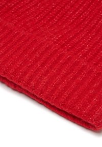 Tessuto di maglia rossa con una texture a coste; il materiale appare morbido e caldo, con dettagli visibili delle fibre.