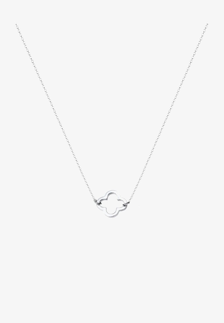 Collier délicat en chaîne argentée avec un petit pendentif en forme de quadrilobe ouvert, centré sur un fond blanc.