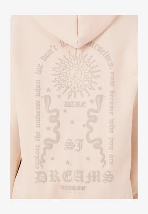 Lyserød hoodie med et stort, struktureret grafik på ryggen, der viser en sol, yin-yang symbol, slanger og stiliseret tekst.
