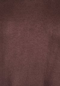 Tumši brūnas ribotas auduma tekstūras tuvplāns, rādot smalkas vertikālas līnijas un mīkstu materiāla virsmu.