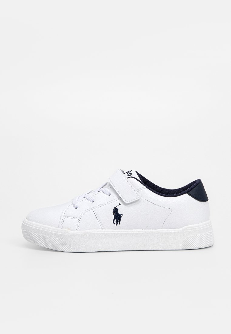 Witte sneaker met een glad bovenwerk van synthetisch materiaal, marineblauwe accenten op de hiel en een klittenbandsluiting. Heeft een logo aan de zijkant en een gestructureerde zool.