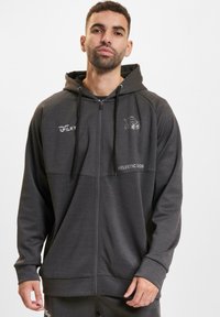 Felpa grigia con zip e cappuccio regolabile, caratterizzata da un logo frontale e testo. Realizzata in tessuto liscio e leggero con maniche lunghe.