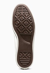 Suola di scarpa in gomma marrone con un motivo geometrico testurizzato, caratterizzata da un bordo bianco e il marchio "Converse All Star".