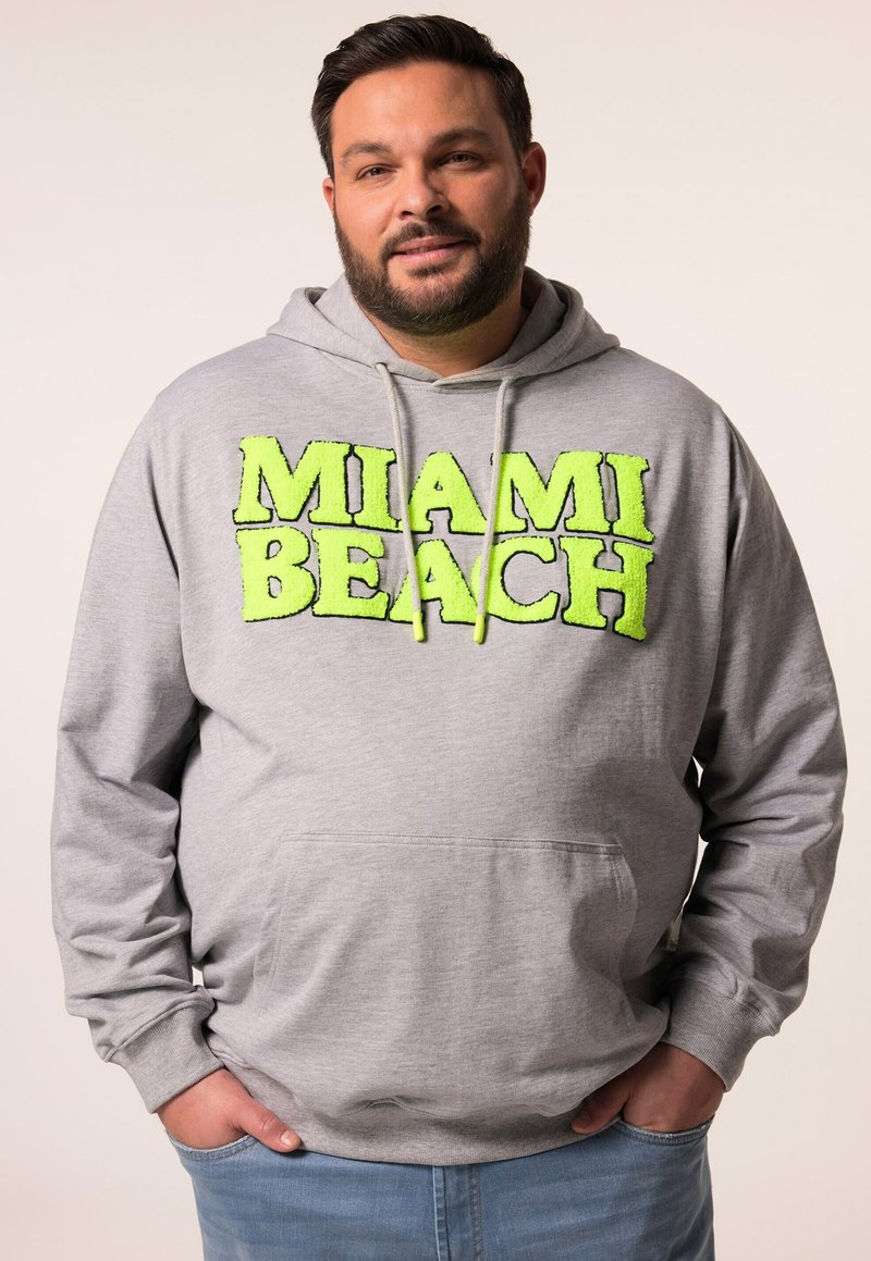 Felpa grigia con "MIAMI BEACH" in lettering fluffy verde neon. Presenta una tasca a marsupio e cappuccio con coulisse. Tessuto morbido e vestibilità rilassata.