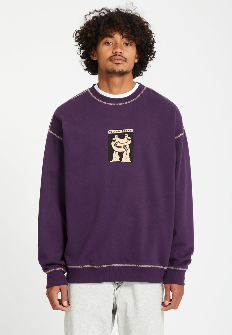 Purple sweatshirt with a white collar, featuring a front graphic in tan and black. Includes contrasting stitching along the seams and cuffs.