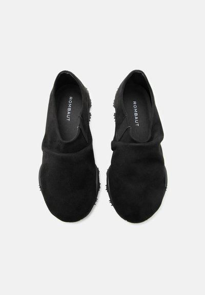 Ζευγάρι μαύρα παπούτσια slip-on με στρογγυλεμένα μύτες, μαλακό σουέτ υλικό και εμφανές όνομα μάρκας "ROMBAUT" μέσα σε κάθε παπούτσι.