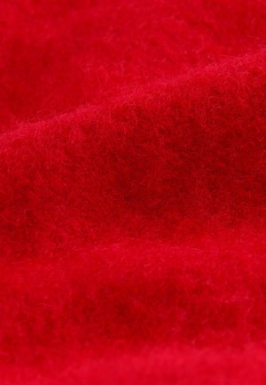 Tissu rouge avec une texture douce et duveteuse, arborant une teinte profonde et un léger éclat. Le matériau semble épais et chaud.