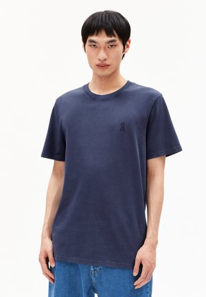 Navy katoenen t-shirt met ronde hals en korte mouwen, voorzien van een klein, donker logo op de linkerborst. Casual pasvorm, minimale textuur.