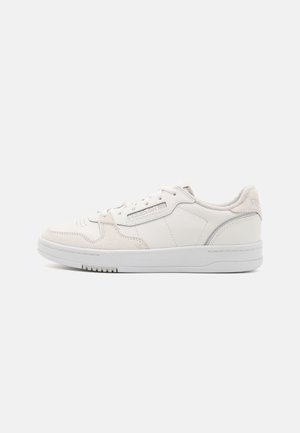 Baskets basses blanches avec lacets, marquage Reebok sur le côté et semelle blanche épaisse sur fond uni.
