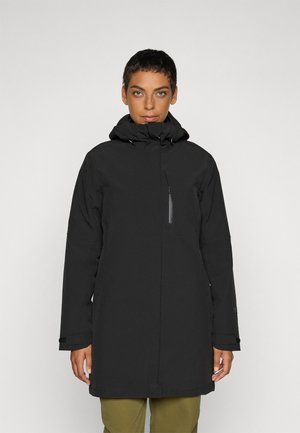 Svart vanntett parkas med høy krage og justerbar hette. Har en sidelomme med glidelås og rett snitt. Stoffet virker glatt og matt.