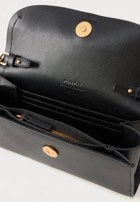 Portafoglio in pelle nera con chiusura magnetica, caratterizzato da scomparti per carte e un comparto con zip. L'hardware dorato aggiunge un tocco di eleganza.