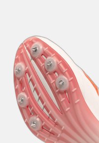 Semelle de chaussure d'athlétisme avec six pointes en métal et des crampons en caoutchouc rose conçus pour une meilleure traction sportive.