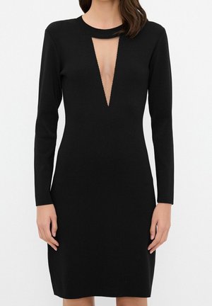 Schwarzes Strickkleid mit langen Ärmeln, tiefem V-Ausschnitt und taillierter Silhouette. Glatte Textur und minimale Nähte.