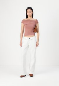 Rausvas offtakio viršus, baltos plačios kojos džinsai, rudas rankinukas ir rudi batai. Lygus audinys, prigludęs viršus ir laisvos apatinės dalies siluetas.