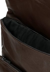 Bruine leren tas met een gestructureerde afwerking. Heeft een zwarte voering en een ritsluiting. Inclusief een extra ritsvak.