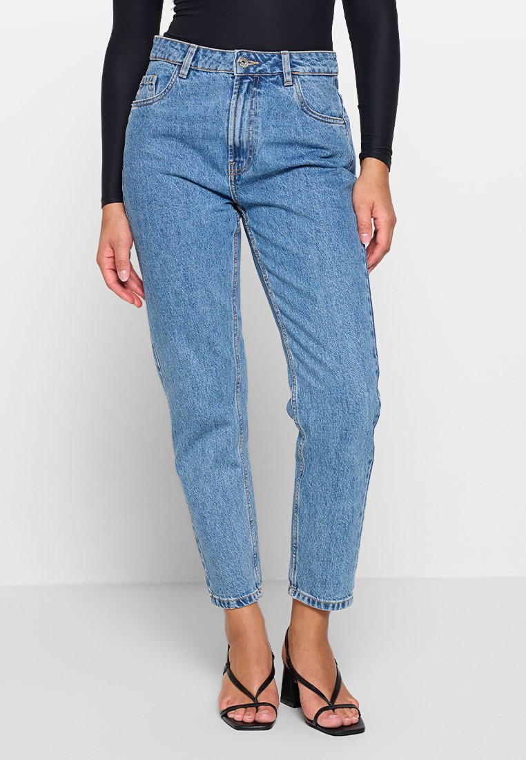 Jasnoniebieskie spodnie typu high-waist wykonane z denimu, o prostym kroju nogawki, pięciopocketowym designie i subtelnym, wyblakłym wykończeniu.