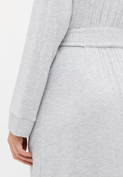 Light grey cotton-knit cardigan featuring ribbed cuffs and waistband, with a smooth texture and a fabric belt around the waist.