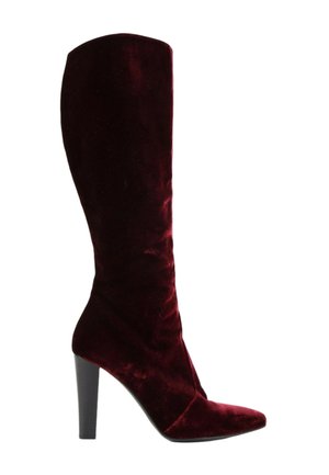 Une botte haute femme unique en velours rouge foncé avec un bout pointu et un talon bloc haut noir.