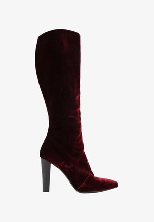 Une botte haute femme unique en velours rouge foncé avec un bout pointu et un talon bloc haut noir.