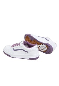Scarpe da ginnastica bianche con accenti e lacci viola. Presentano una suola in gomma con grip testurizzato e due strisce curve sui lati.