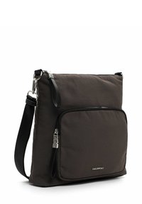 Bolso cruzado de nylon negro con un bolsillo frontal con cremallera, correa ajustable y acentos de hardware plateado. Acabado de tejido suave y texturizado.