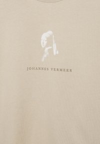 Verblasste weiße Silhouette einer Frau mit Kopftuch über dem Text „JOHANNES VERMEER“ auf beigem Stoff.