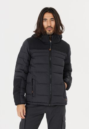 Svart vadderad jacka med dragkedja och huva. Har kontrasterande matt tyg på axlarna och subtila orange detaljer.