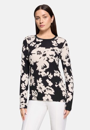 Zwarte en beige bloemetjes top met lange mouwen, voorzien van een ronde hals, abstracte bloemenpatronen en een getailleerd ontwerp. Zacht stof met subtiele textuur.