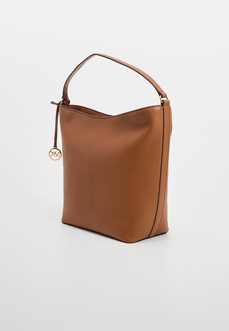 Bolso de cuero marrón con un acabado texturizado, un asa única y un colgante circular dorado adjunto. Forma sencilla y informal.