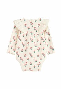 Ilgais rankovės kūdikių bodysuit iš kreminės ribotuvo medžiagos, su raudonais ir žaliais gėlių raštais, nėriniuotomis volanėlėmis ir spaustukais nugarinėje dalyje.