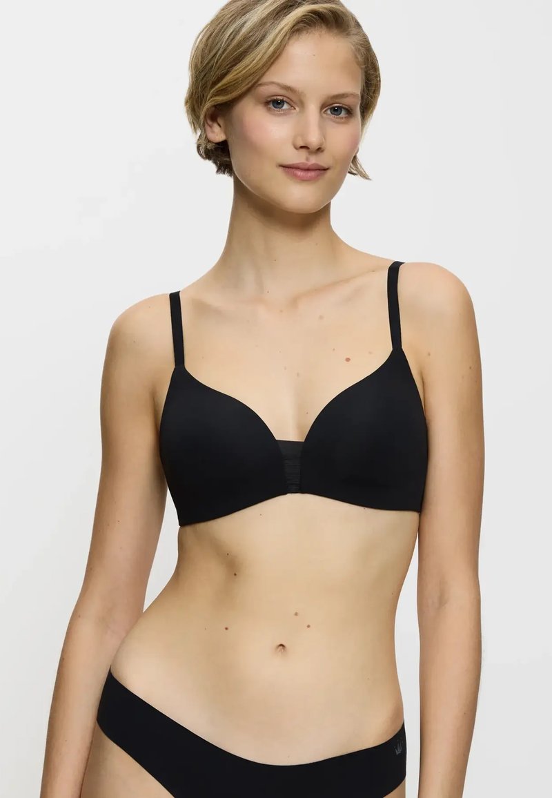 Senza ferretti, reggiseno wireless nero con spalline regolabili e una texture liscia. Caratterizzato da un collo a V e design senza cuciture, abbinato a slip coordinati.