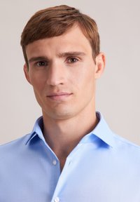 Lichtblauw overhemd met kraag, gemaakt van een gladde stof, met een knoopsluiting aan de voorkant en gestikte details op de kraag en manchetten.