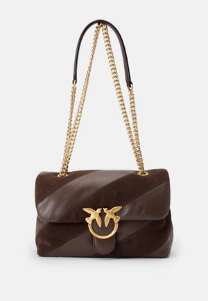 Borsa in pelle e suede marrone con tracolla a catena, caratterizzata da un emblema d'oro a forma di uccello e accenti di design diagonali. Forma compatta e strutturata.