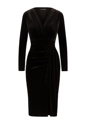 Zwarte fluwelen jurk met lange mouwen, diepe V-hals en wikkelontwerp. Bevat een gedrapeerde taille en een hoge split voor extra detail.