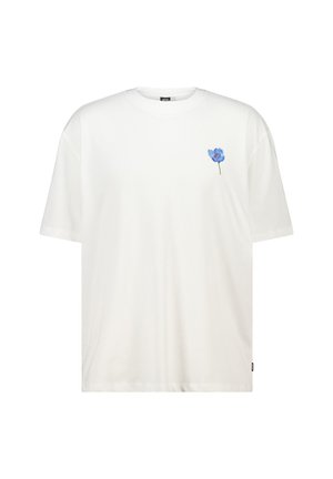 T-shirt en coton blanc avec un graphisme de fleur bleue sur la partie gauche de la poitrine. Design classique à col rond et coupe décontractée.