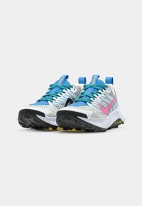 Sporty running shoes featuring a white mesh upper with blue and pink accents, textured black outsole, and vibrant blue laces.