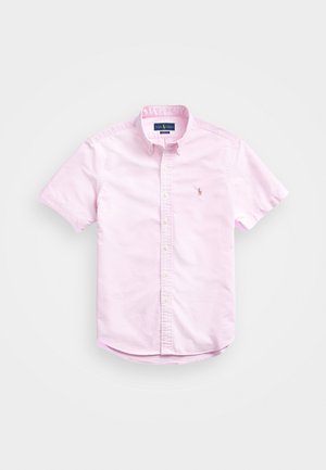 Short-sleeve, button-up shirt in light pink cotton with a classic collar and small embroidered logo on the chest. Features rounded hem.