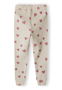 Leggings de canalé beige con un patrón disperso de corazones rosas; cuentan con puños en los tobillos ajustados y una cintura elástica.